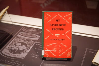 A close-up of a small book with a bright red cover. The book's title and author is My Favourite Recipes by Ellice Handy.