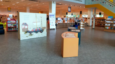 A photo of the teaser exhibition, which is a horizontally curved lightbox panel.