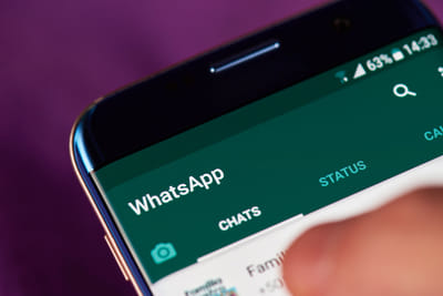 A close-up photo of a phone with Whatsapp open on it.