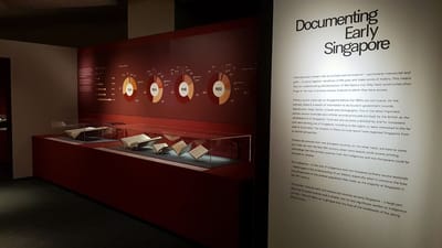 A photo of the Documenting Early Singapore section. Various Straits Settlement records are in the showcases. On the wall, there are donut charts depicting population percentages.