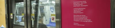 A photo of an MRT door, with a Poetry on Platforms poetry sticker on it.