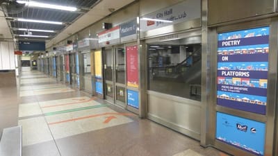 A row of MRT doors with poetry stickers.