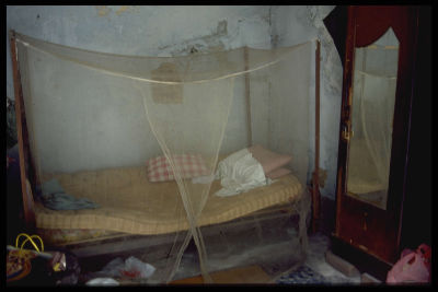A sagging mattress covered by a translucent netting, inside a bedroom at Kampong Bugis.