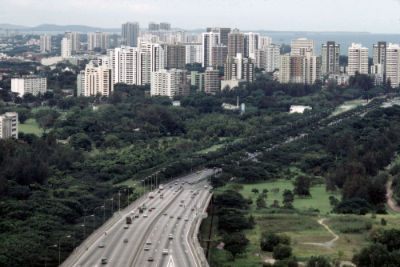 An expressway with numerous high-rise buildings in the background.