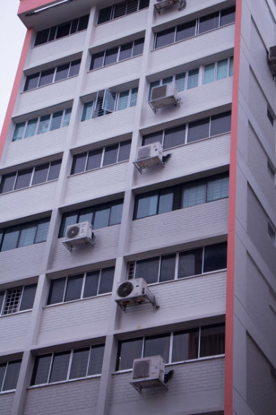 Air-con units underneath bedroom windows stand out from a high-rise block in Yishun.