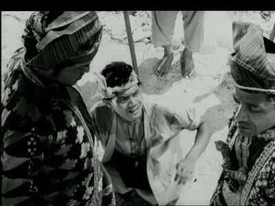 A black and white film still from the movie, 'Hang Jebat'. Three men are in the scene.